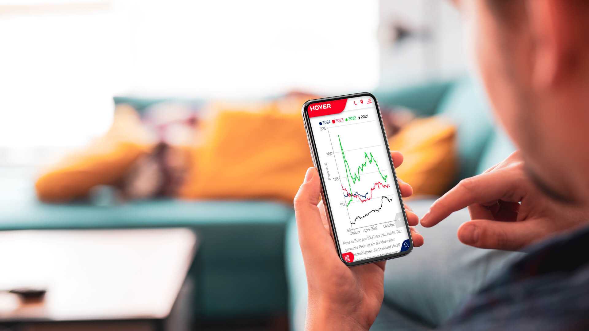 Mensch sieht in seinem Smartphone einen Preisverlauf auf dem Bildschirm